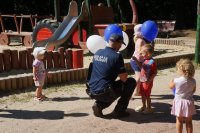 Zdjęcie kolorowe, przedstawiające policjantów z dziećmi.