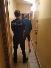 Zdjęcie przedstawiające policjanta oraz zatrzymanego.