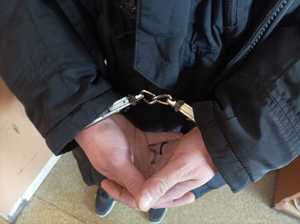 Zdjęcie przedstawiające ręce zatrzymanego, na które założone są kajdanki.