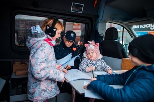 Zdjęcie przedstawiające policjantkę oraz dzieci w radiowozie.