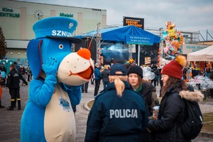 Zdjęcie przedstawiające Sznupka, policjantkę i osoby zebrane przy maskotce.