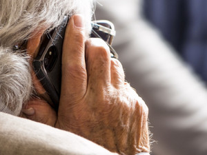 Zdjęcie osoby starszej rozmawiającej przez telefon.